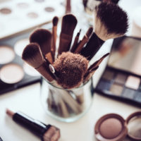 Professional makeup brushes and tools, natural make-up products set on white table.